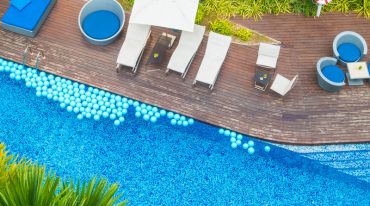 Aerial view of Beautiful luxury hotel swimming pool resort with umbrella and chair - Boost up color processing